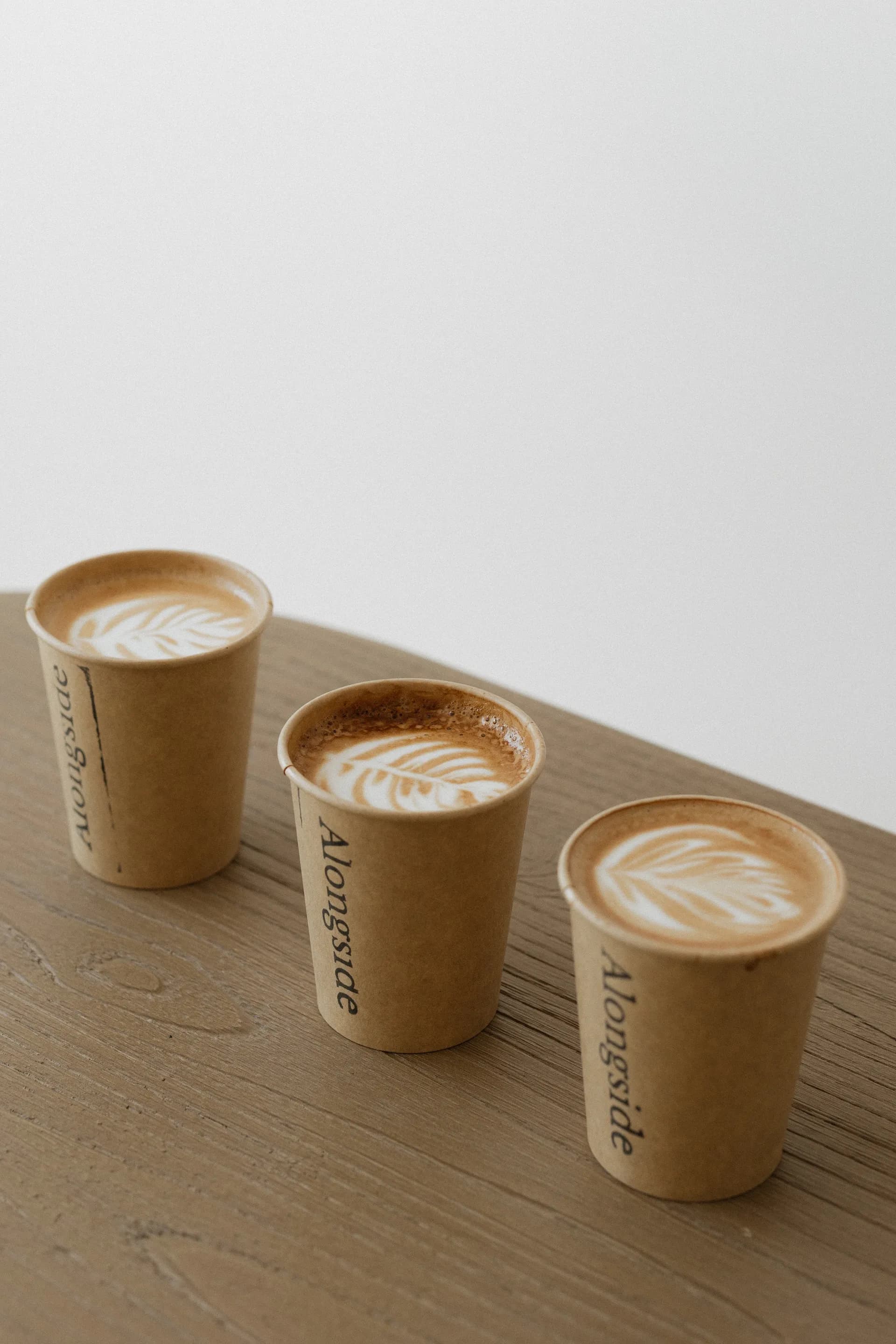 Three Alongside Coffee cups with latte art